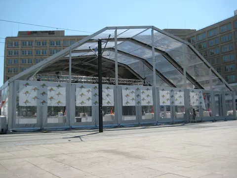 Carpa de cristal de gran luz montada en una plaza urbana